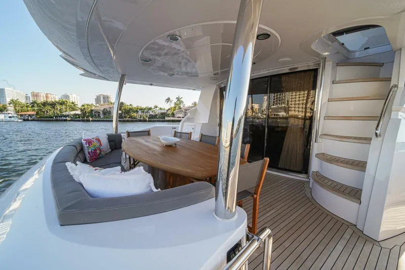 El Tio Yacht Photos Pics Luxurious 2006 Sunseeker 90 Yacht deck with seating, table, and scenic waterfront view.