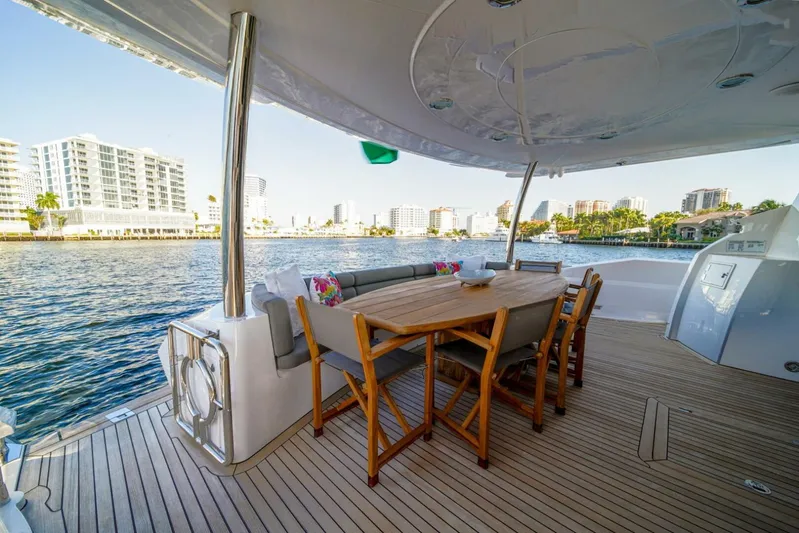 El Tio Yacht Photos Pics Sunseeker 90 Yacht 2006 deck with dining area overlooking waterfront cityscape.