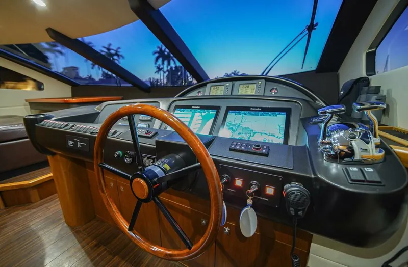 El Tio Yacht Photos Pics Helm of 2006 Sunseeker 90 Yacht with modern navigation equipment and wooden steering wheel.