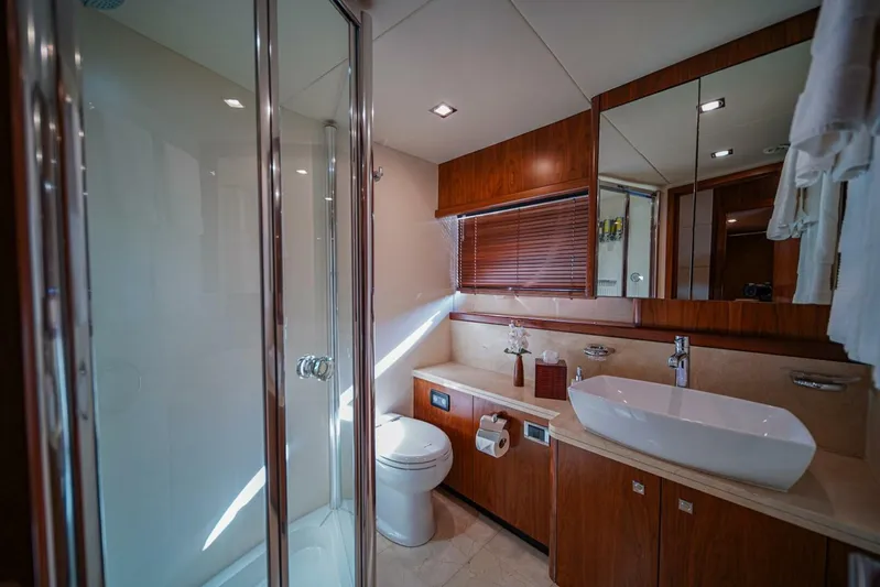 El Tio Yacht Photos Pics Luxurious bathroom in 2006 Sunseeker 90 Yacht with modern fixtures and wooden cabinetry.