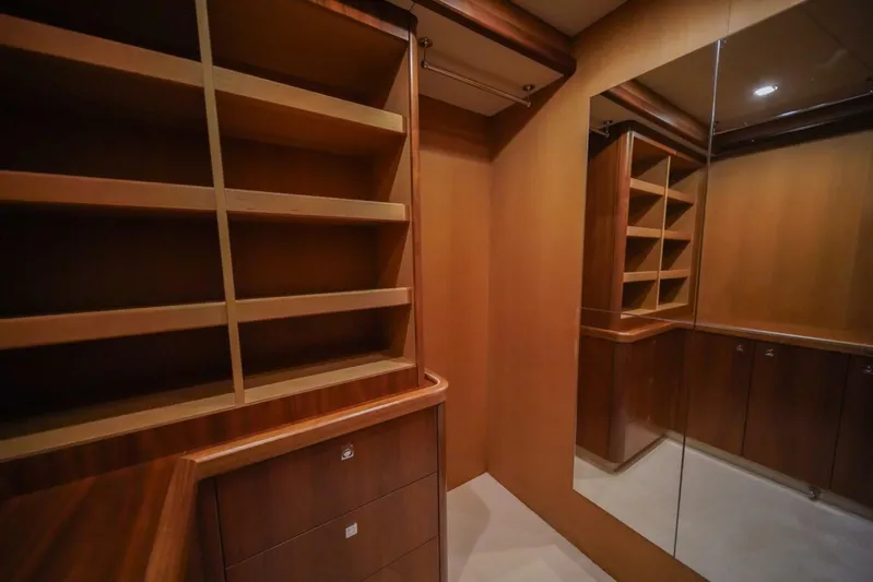 El Tio Yacht Photos Pics Luxurious wooden interior of a 2006 Sunseeker 90 Yacht with shelving and mirrored wall.