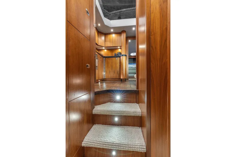 Ohana Forever Yacht Photos Pics Luxurious interior of 2016 Sunseeker Manhattan 55 yacht with wooden finishes and carpeted steps.