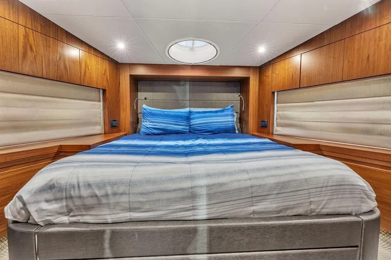 Ohana Forever Yacht Photos Pics Luxurious bedroom interior of 2016 Sunseeker Manhattan 55 yacht with wood paneling and blue bedding.