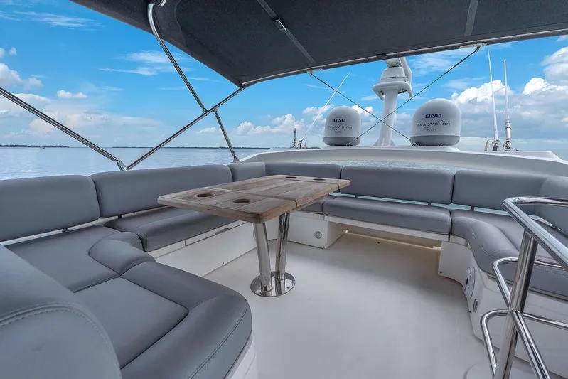 Ohana Forever Yacht Photos Pics 2016 Sunseeker Manhattan 55 yacht deck with seating and table, under a clear blue sky.