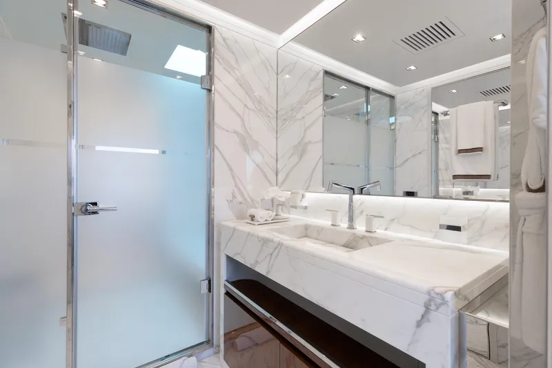 Goldeneye Yacht Photos Pics Luxurious marble bathroom in 2020 Mangusta 54 Gransport yacht, featuring modern fixtures and elegant design.