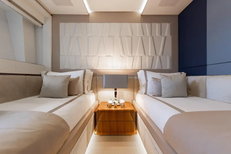 Goldeneye Yacht Photos Pics Luxurious twin bedroom on 2020 Mangusta 54 Gransport yacht, featuring modern decor and ambient lighting.