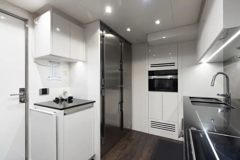 Goldeneye Yacht Photos Pics Modern kitchen interior of 2020 Mangusta 54 Gransport yacht, featuring sleek appliances and cabinetry.