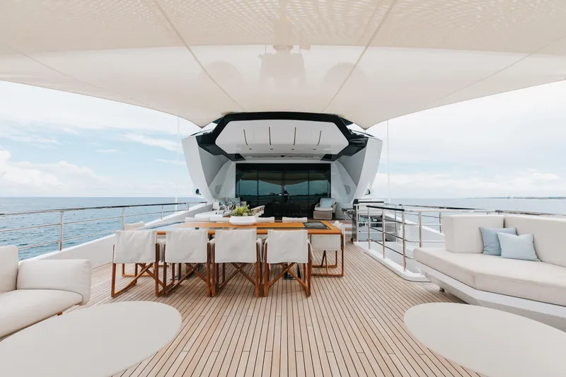Goldeneye Yacht Photos Pics Luxurious 2020 Mangusta 54 Gransport yacht deck with elegant dining area and ocean view.
