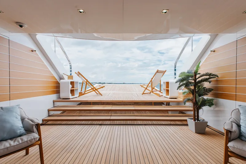 Goldeneye Yacht Photos Pics Luxurious deck of 2020 Mangusta 54 Gransport yacht with wooden flooring and lounge chairs.