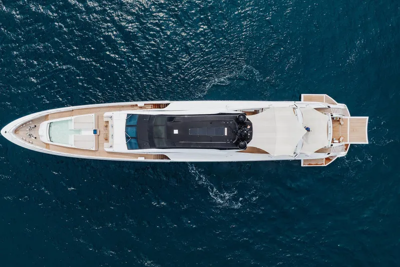 Goldeneye Yacht Photos Pics Aerial view of 2020 Mangusta 54 Gransport yacht cruising on blue ocean waters.