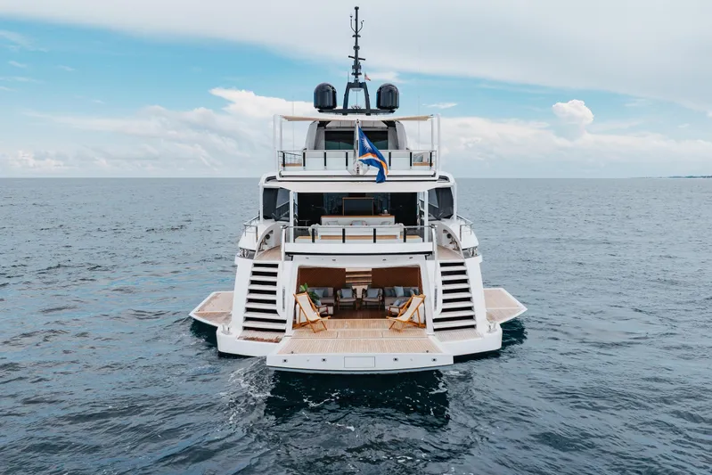 Goldeneye Yacht Photos Pics 2020 Mangusta 54 Gransport luxury yacht on open sea, rear view.