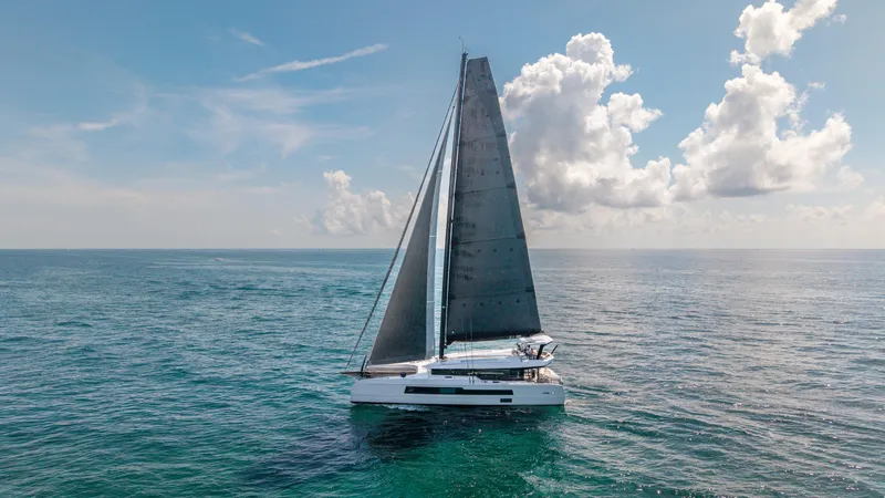 Noble House Yacht Photos Pics 2019 McConaghy MC60 sailing on open ocean under a clear blue sky.