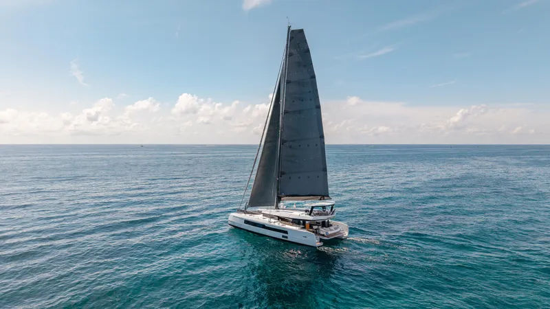Noble House Yacht Photos Pics 2019 McConaghy MC60 sailing on open ocean under clear blue sky.