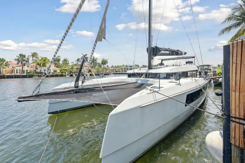 Noble House Yacht Photos Pics 2019 McConaghy MC60 catamaran docked in a scenic waterfront setting.