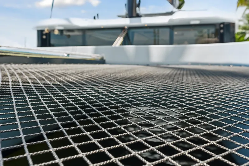 Noble House Yacht Photos Pics Trampoline netting on 2019 McConaghy MC60 catamaran, with blurred cabin in background.
