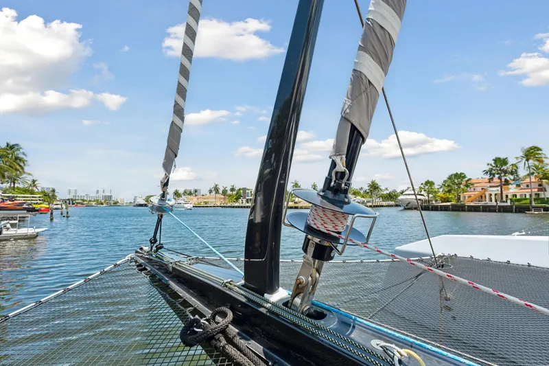 Noble House Yacht Photos Pics 2019 McConaghy MC60 sailboat on a sunny waterfront, showcasing rigging and netting.