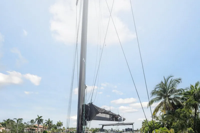 Noble House Yacht Photos Pics 2019 McConaghy MC60 yacht mast against a clear blue sky with palm trees.