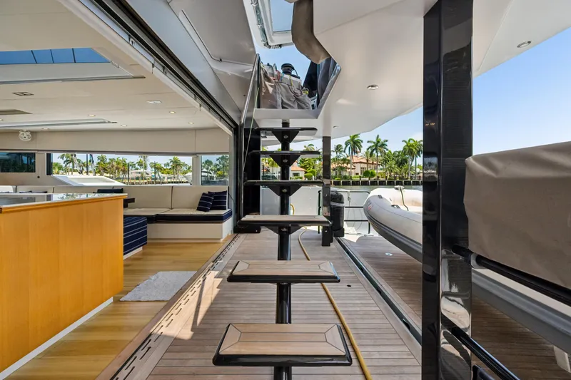Noble House Yacht Photos Pics Luxurious interior of 2019 McConaghy MC60 yacht with modern staircase and seating area.