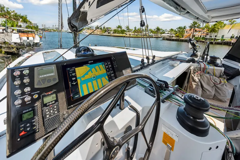 Noble House Yacht Photos Pics Cockpit view of 2019 McConaghy MC60 yacht with navigation equipment and scenic waterfront.