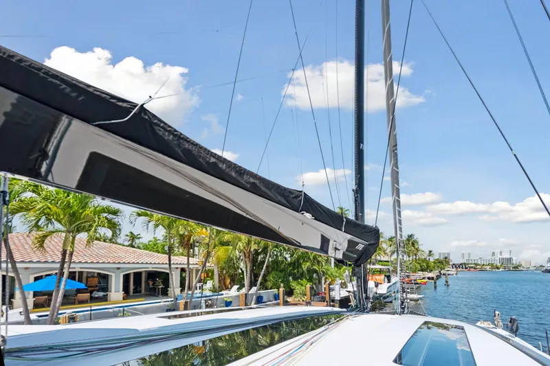 Noble House Yacht Photos Pics 2019 McConaghy MC60 yacht docked by waterfront homes under a clear blue sky.