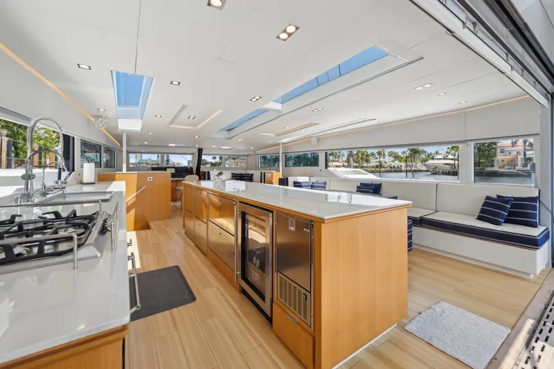 Noble House Yacht Photos Pics Luxurious interior of 2019 McConaghy MC60 yacht with modern kitchen and seating area.