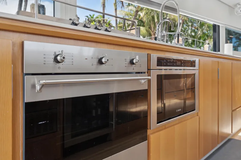 Noble House Yacht Photos Pics Modern kitchen appliances in a 2019 McConaghy MC60 yacht, featuring an oven and microwave.