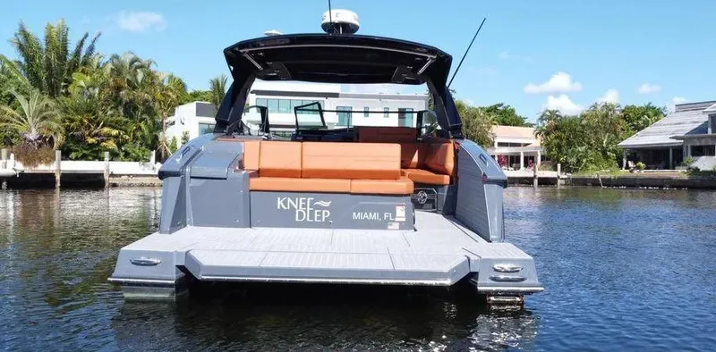  Yacht Photos Pics 2023 Cruisers Yachts 38 GLS on water, rear view with seating, Miami backdrop.