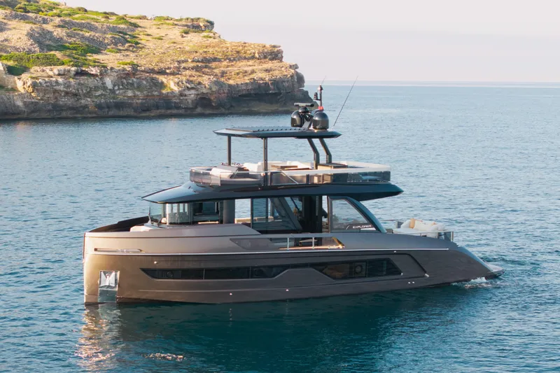  Yacht Photos Pics Luxurious 2025 Explorer 62 yacht cruising near rocky coastline.