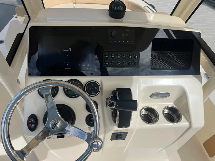  Yacht Photos Pics 2025 Scout 231 XSB boat dashboard with steering wheel, Garmin display, and control panel.