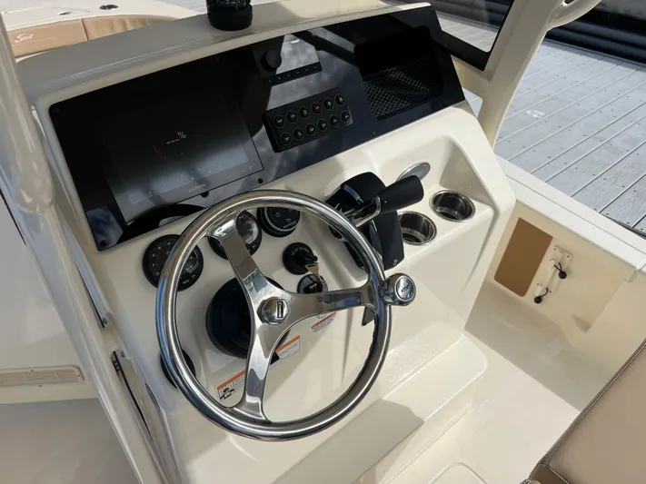  Yacht Photos Pics 2025 Scout 231 XSB boat dashboard with steering wheel and control panel.