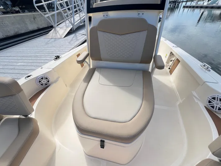  Yacht Photos Pics 2025 Scout 231 XSB boat interior with beige seating and storage, dockside view.