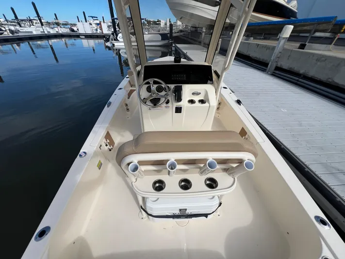  Yacht Photos Pics 2025 Scout 231 XSB boat interior at marina, featuring helm and seating.