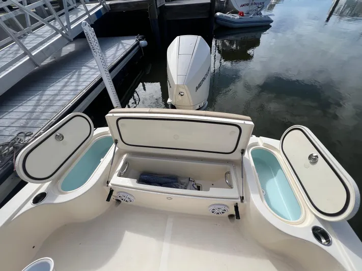  Yacht Photos Pics 2025 Scout 231 XSB boat with open storage compartments and Mercury engine at dock.