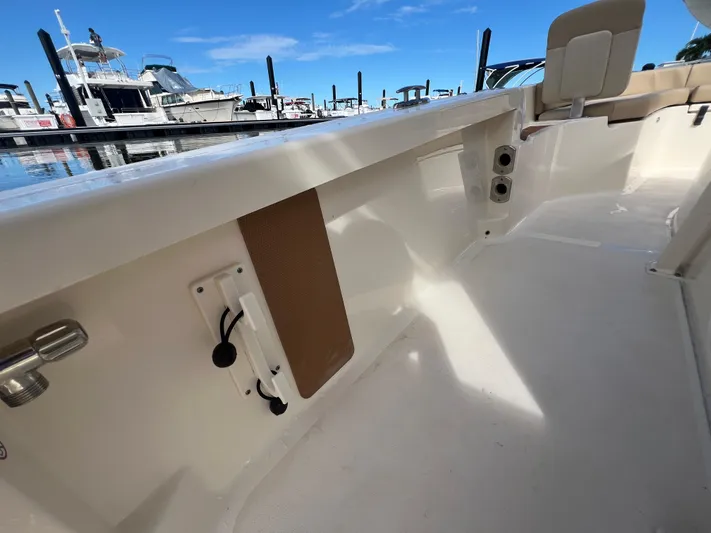  Yacht Photos Pics 2025 Scout 231 XSB boat interior at marina, showcasing seating and deck features.