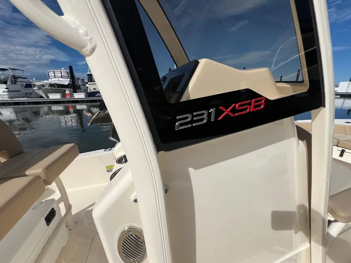  Yacht Photos Pics 2025 Scout 231 XSB boat interior with console and seating at marina.
