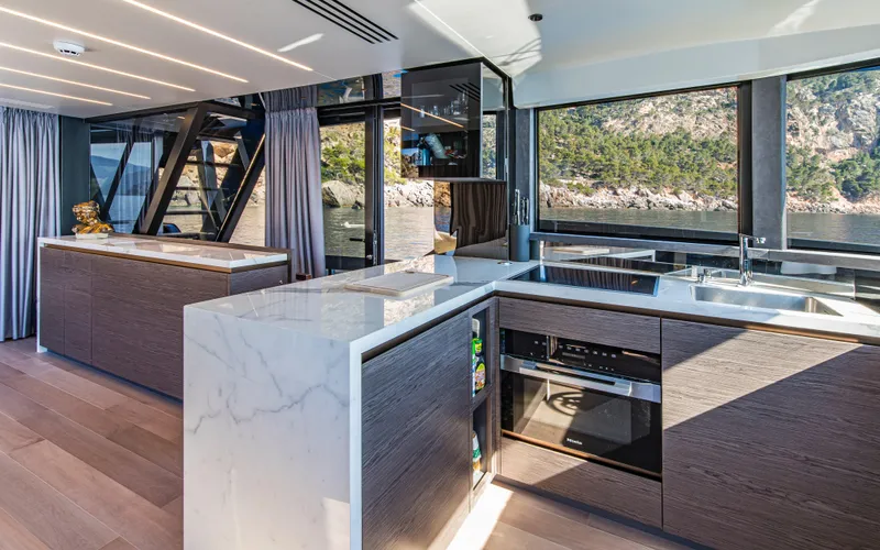  Yacht Photos Pics Modern yacht kitchen with marble countertops, sleek cabinetry, and scenic ocean views. Explorer 62, 2025 model.