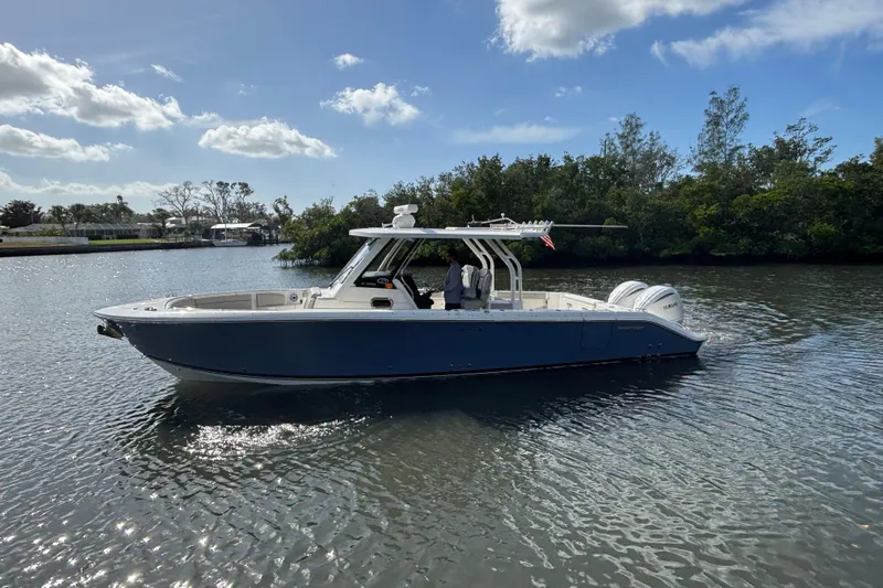  Yacht Photos Pics 2023 Pursuit S 328 Sport boat on calm water under a clear sky.