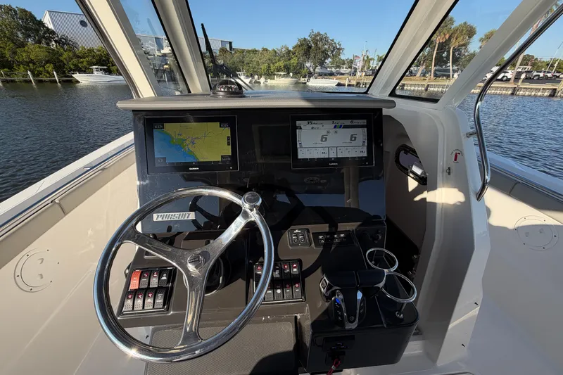  Yacht Photos Pics 2023 Pursuit S 328 Sport boat helm with navigation screens and steering wheel.