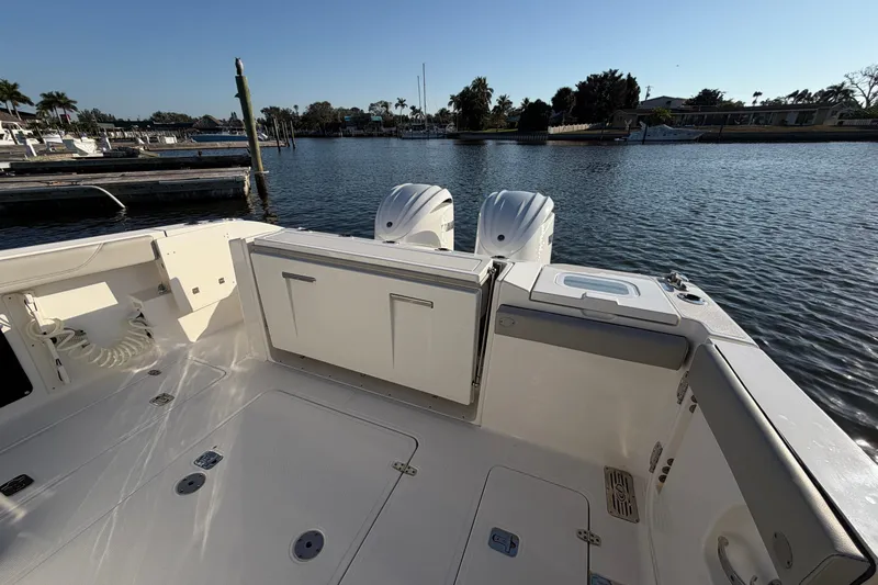  Yacht Photos Pics 2023 Pursuit S 328 Sport boat at marina, featuring spacious deck and dual engines.