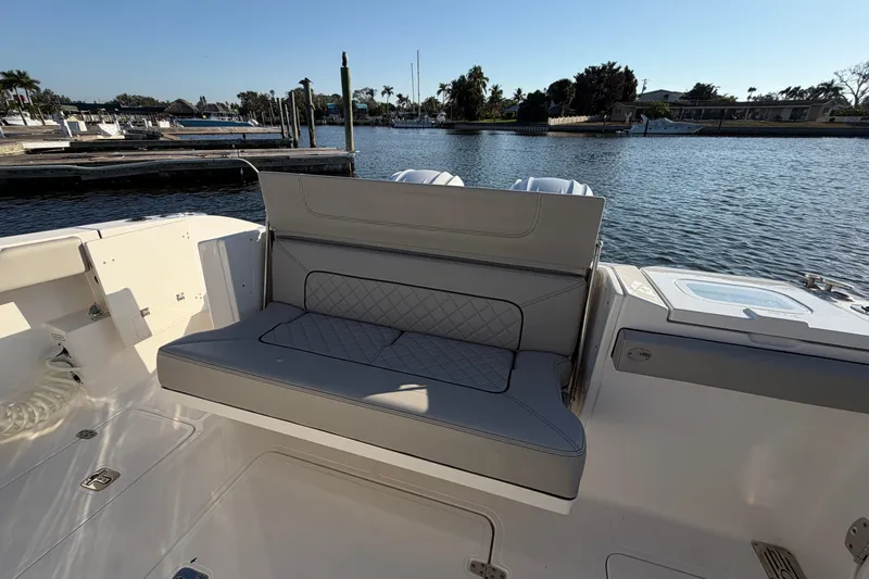  Yacht Photos Pics 2023 Pursuit S 328 Sport boat interior with cushioned seating by the water.