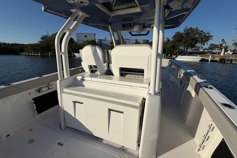  Yacht Photos Pics 2023 Pursuit S 328 Sport boat interior with seating and storage, docked by the water.