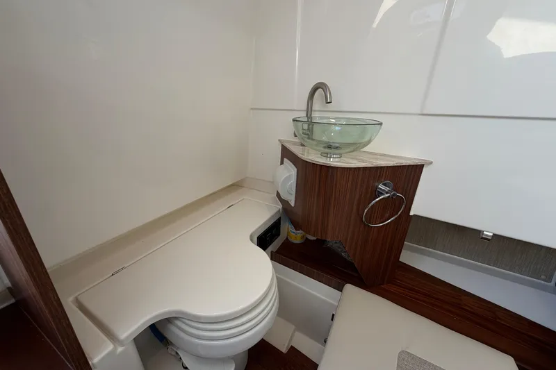  Yacht Photos Pics 2023 Pursuit S 328 Sport boat bathroom with modern sink and compact toilet.
