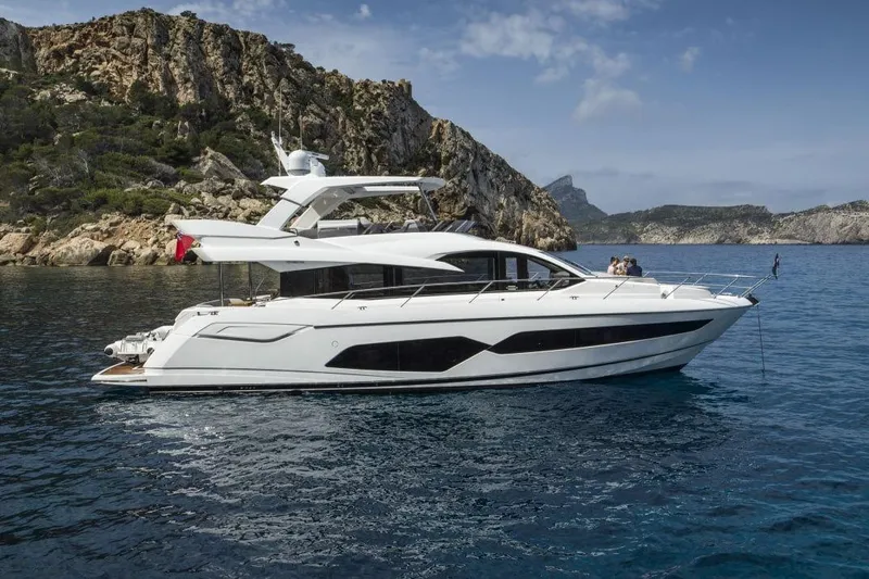  Yacht Photos Pics 2019 Sunseeker Manhattan 66 yacht cruising near rocky coastline.