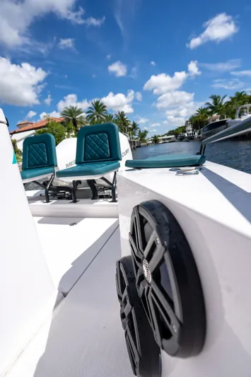  Yacht Photos Pics 2023 Axopar 28 T-Top boat with teal seats, cruising on a sunny day.