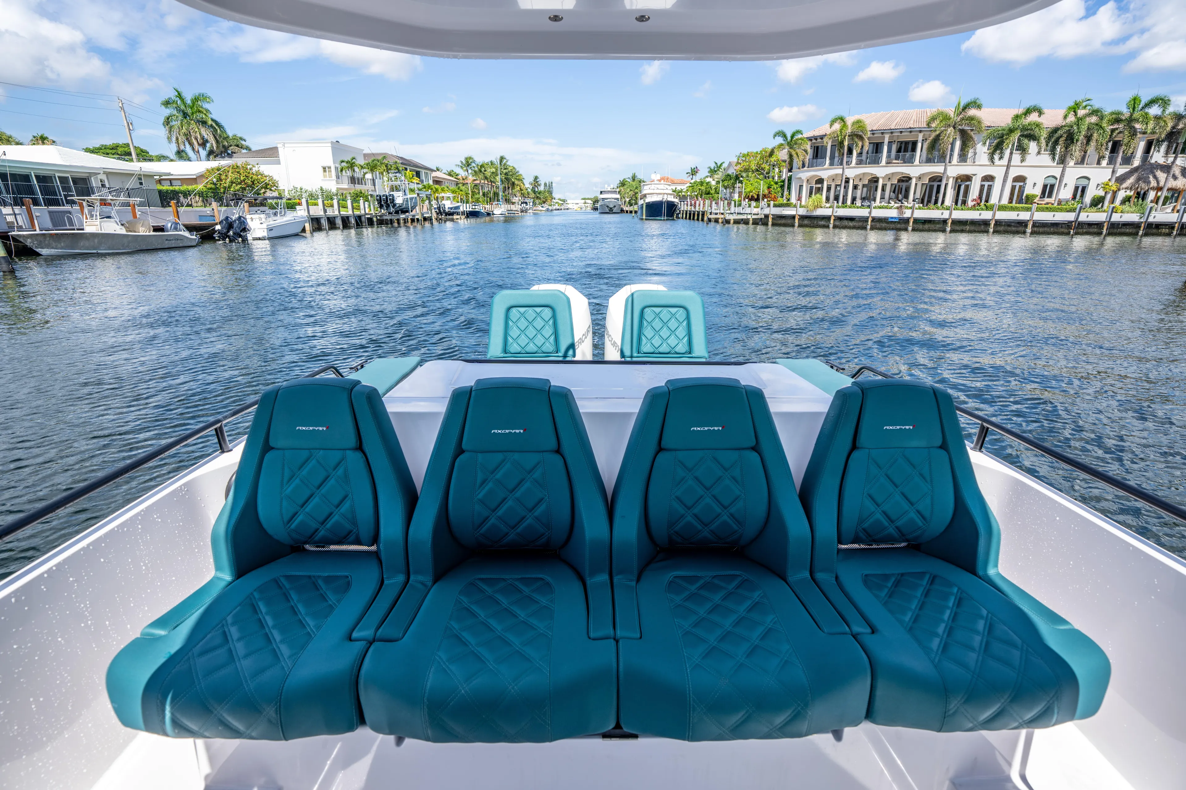  Yacht Photos Pics 2023 Axopar 28 T-Top boat with teal seating, cruising on a scenic waterway.