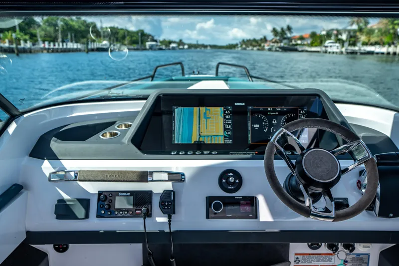  Yacht Photos Pics 2023 Axopar 28 T-Top boat dashboard with navigation screens and steering wheel.