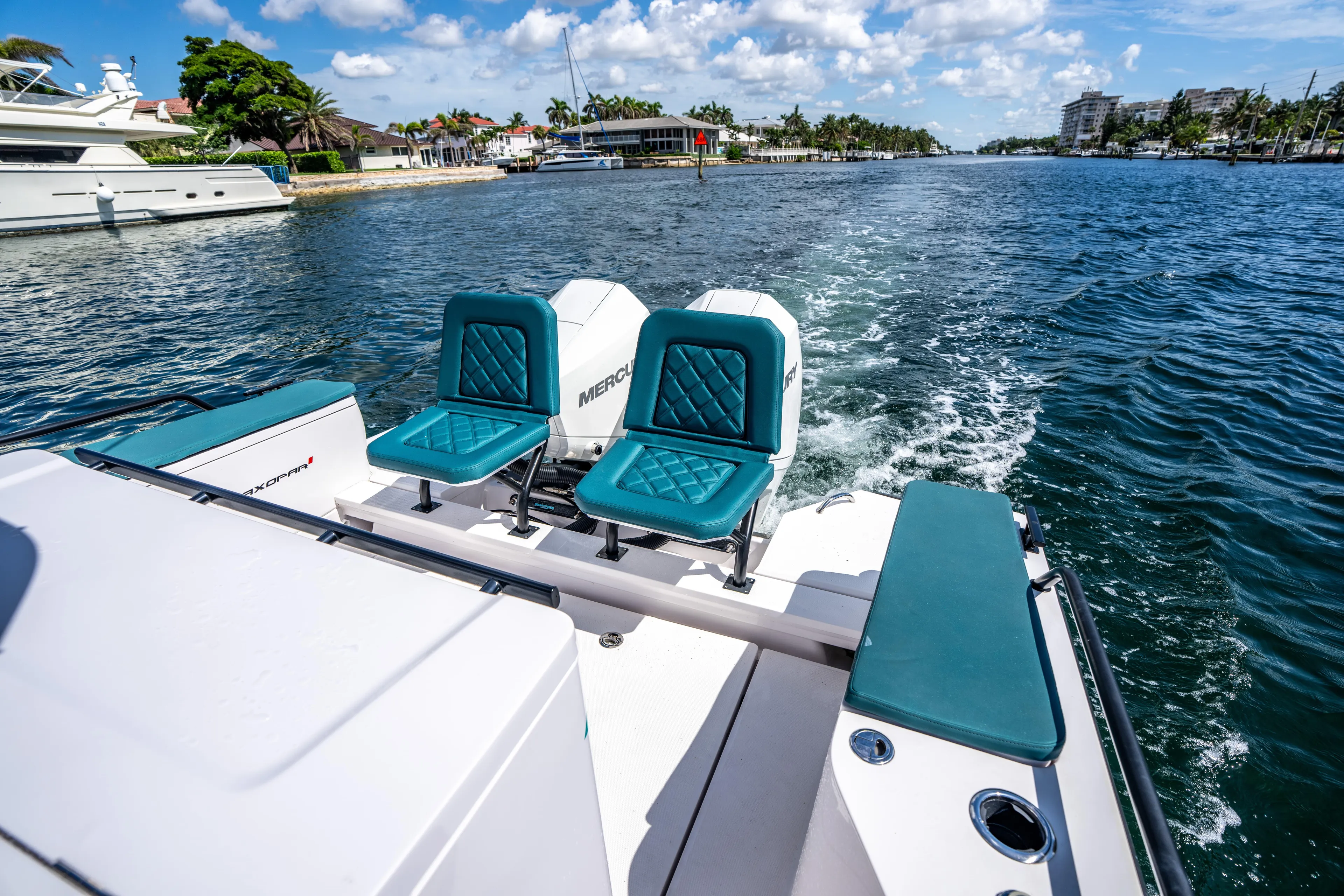  Yacht Photos Pics 2023 Axopar 28 T-Top boat with teal seats cruising on a sunny day.