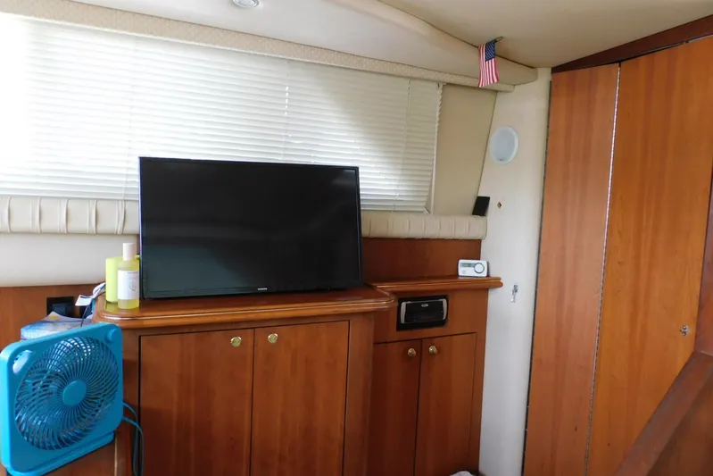 How Lucky Yacht Photos Pics Interior of 2003 Cruisers Yachts 3750 Motoryacht with TV, fan, and wooden cabinetry.