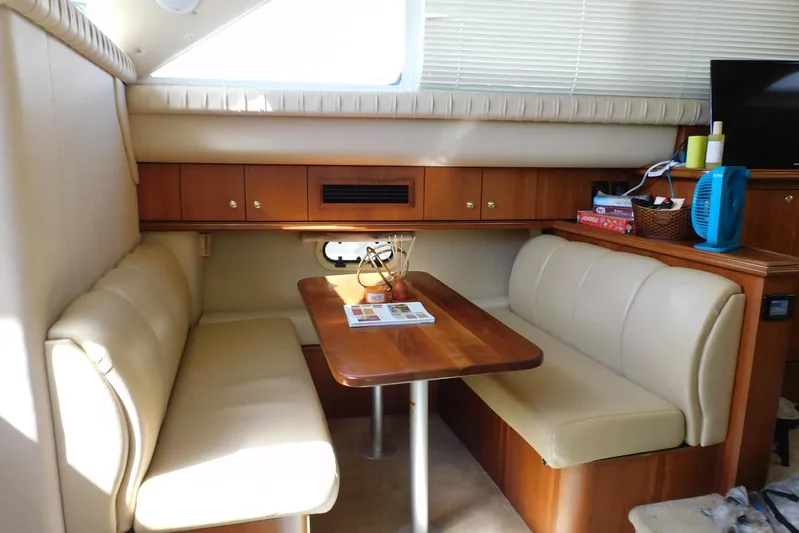 How Lucky Yacht Photos Pics 2003 Cruisers Yachts 3750 Motoryacht interior with cozy dining area and wooden cabinetry.