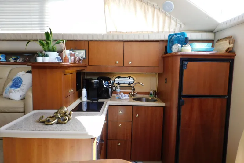 How Lucky Yacht Photos Pics 2003 Cruisers Yachts 3750 Motoryacht interior kitchen with wooden cabinets and modern appliances.